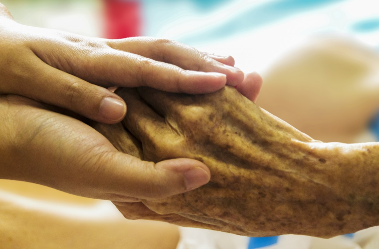holding a senior's hand
